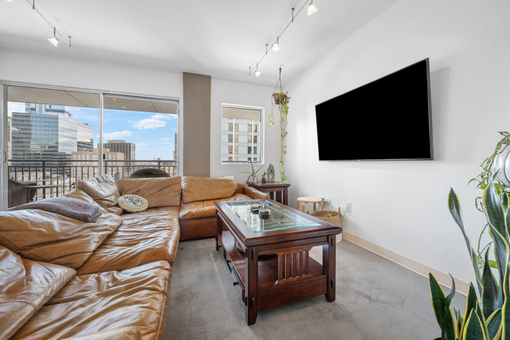 Austin real estate photography featuring a luxury downtown condominium living room with modern furnishings, natural light, and professional interior photography.