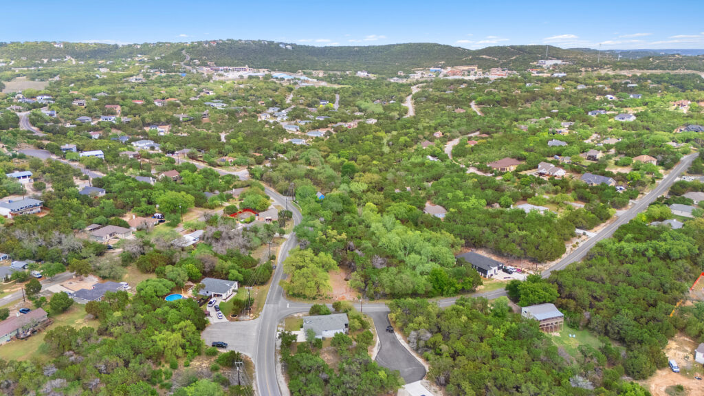 Lago Vista real estate photography featuring a drone aerial view of a residential lot with surrounding Hill Country landscape near Lake Travis.