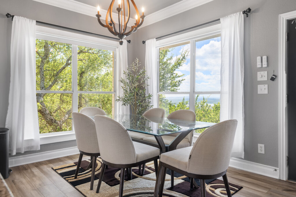 Lago Vista real estate photography featuring a dining room with panoramic Lake Travis views, elegant finishes, and professionally captured interior photography.