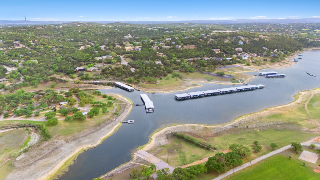 Lago Vista real estate photography featuring a drone aerial view of the LVPOA Marina on Lake Travis and the surrounding waterfront community.