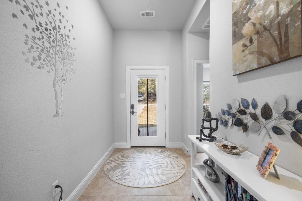 Lago Vista real estate photography featuring a welcoming front entryway and custom front door with elegant architectural details and professional interior photography.