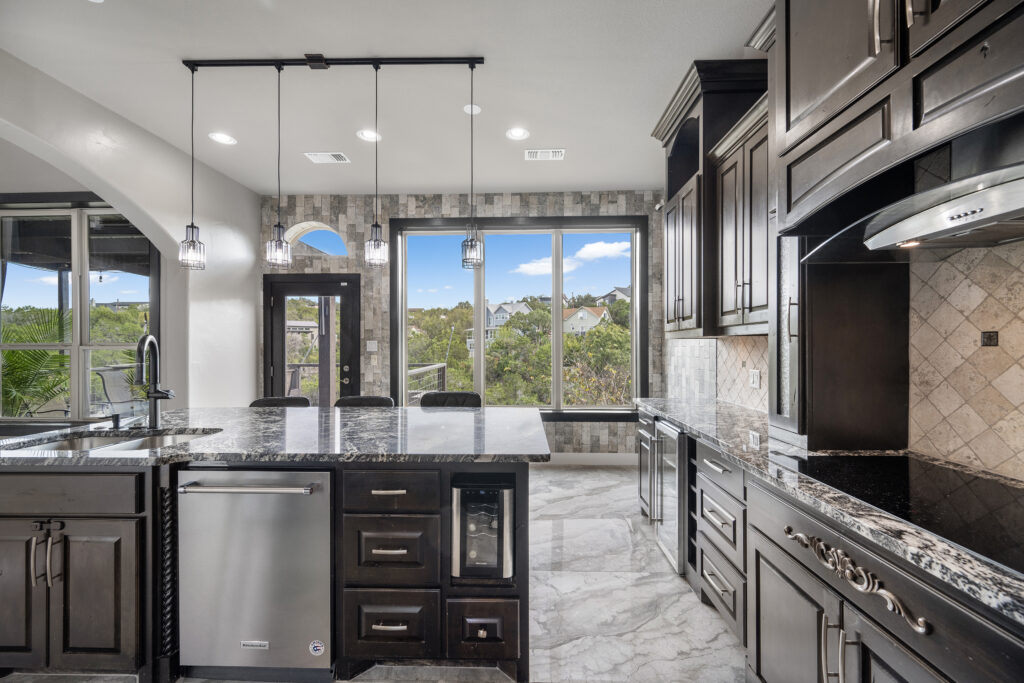 Luxury kitchen with panoramic Lake Travis views photographed by ATXPhotoDude, a professional real estate photographer specializing in luxury waterfront homes.